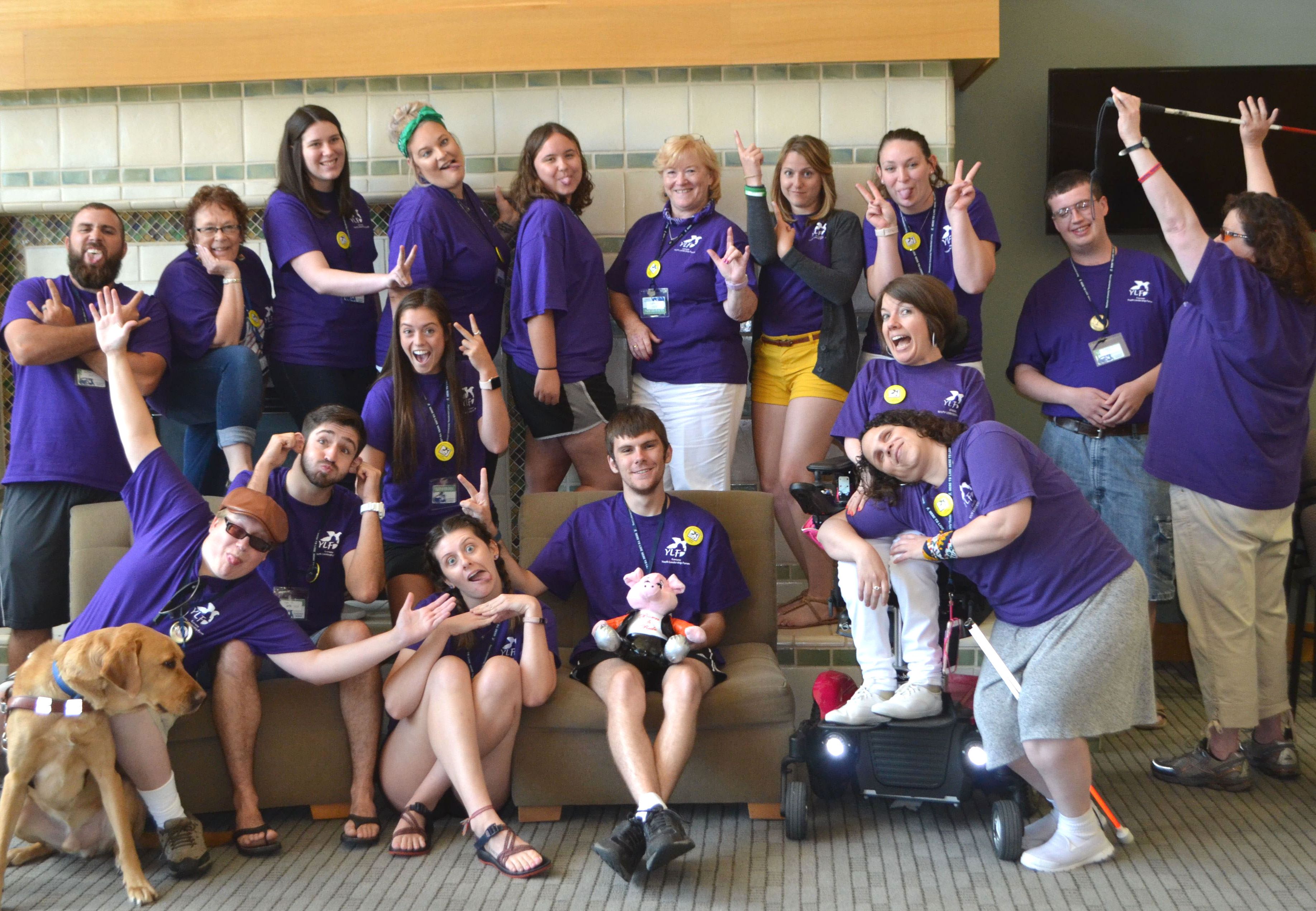 A group of KSYLF volunteers wearing purple shirts take a silly group photo.